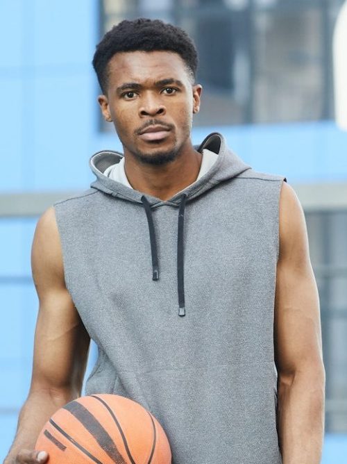 A man basketball player posing and holding ball in hands